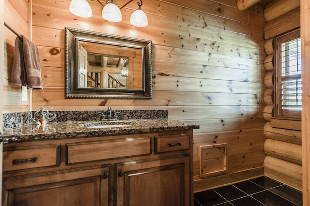 bathroom featuring vanity, rustic walls, tile patterned flooring, and toilet