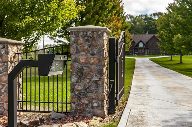 view of gate with a lawn