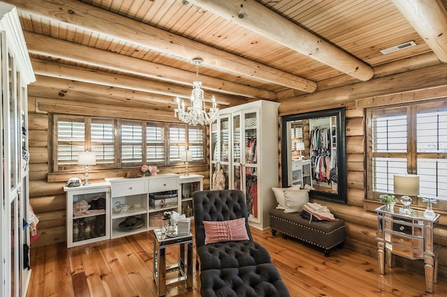 living area with light wood-type flooring, a healthy amount of sunlight, and log walls