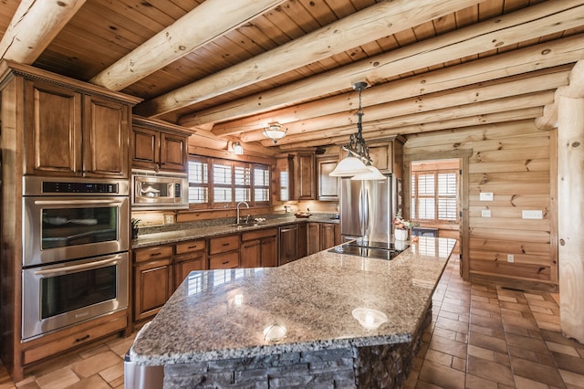 kitchen featuring dark stone countertops, beamed ceiling, appliances with stainless steel finishes, and a kitchen island