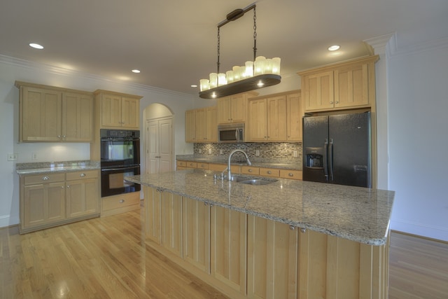 kitchen featuring light hardwood / wood-style floors, pendant lighting, black appliances, crown molding, and sink