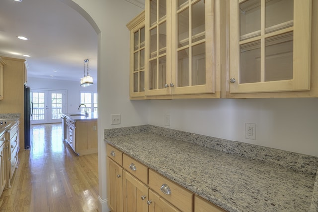 kitchen with sink, hanging light fixtures, light hardwood / wood-style flooring, refrigerator, and french doors