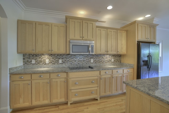 kitchen featuring ornamental molding, stovetop, light hardwood / wood-style flooring, and black refrigerator with ice dispenser