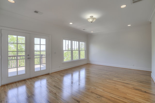 empty room with french doors, light wood-type flooring, plenty of natural light, and crown molding