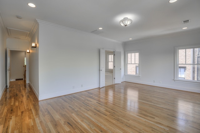 spare room featuring ornamental molding and light hardwood / wood-style flooring