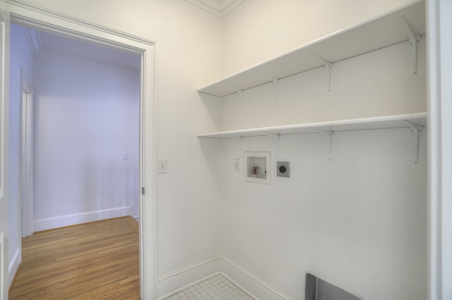 washroom with hookup for a washing machine, hardwood / wood-style floors, ornamental molding, and electric dryer hookup