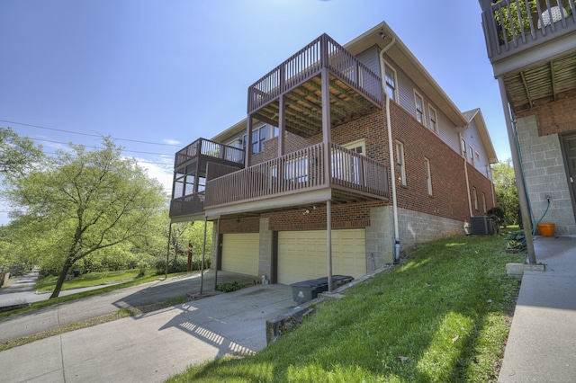 view of front facade featuring a front yard, a garage, a wooden deck, and central air condition unit