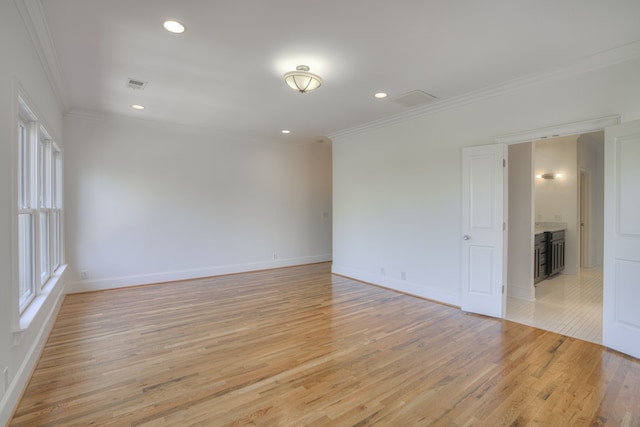 spare room with crown molding and light hardwood / wood-style flooring