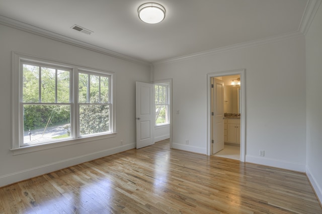 unfurnished room featuring light hardwood / wood-style flooring, a wealth of natural light, and crown molding