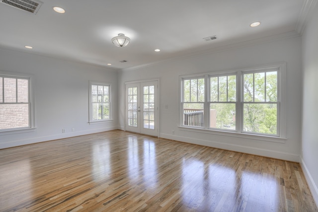 spare room with crown molding, light hardwood / wood-style flooring, and french doors