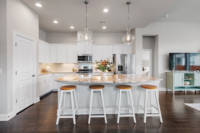 kitchen featuring white cabinetry, appliances with stainless steel finishes, dark hardwood / wood-style floors, and a kitchen island