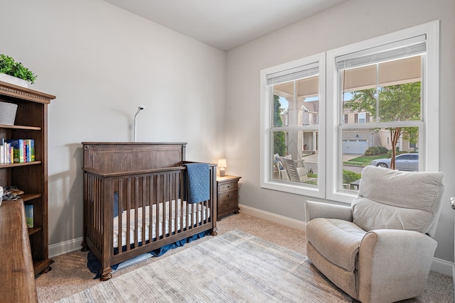 carpeted bedroom with multiple windows and a crib