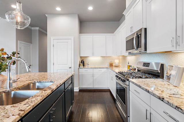 kitchen featuring pendant lighting, sink, white cabinetry, appliances with stainless steel finishes, and dark hardwood / wood-style flooring