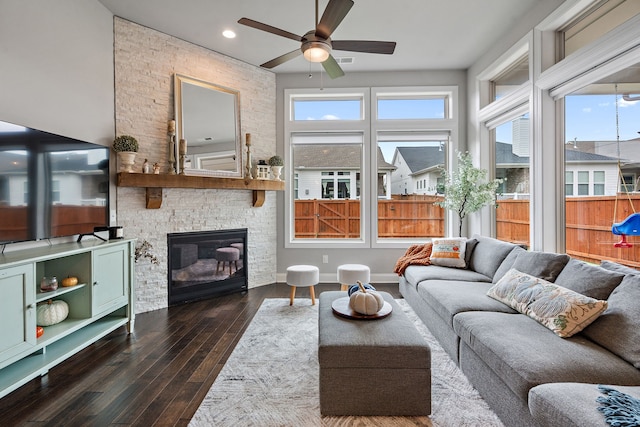 living room featuring ceiling fan, a fireplace, and dark hardwood / wood-style flooring