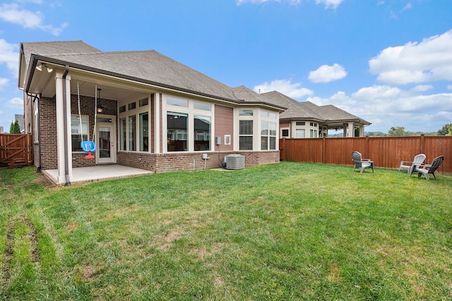 rear view of property featuring a patio, central air condition unit, and a yard