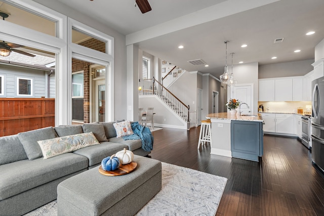 living room with ceiling fan, dark hardwood / wood-style floors, and sink