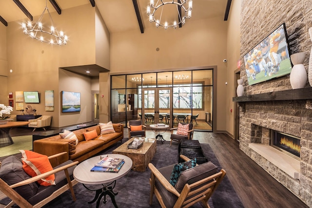 living room with a stone fireplace, beamed ceiling, a notable chandelier, and dark hardwood / wood-style floors