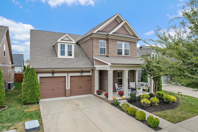 craftsman-style house with central AC unit, a front yard, a porch, and a garage