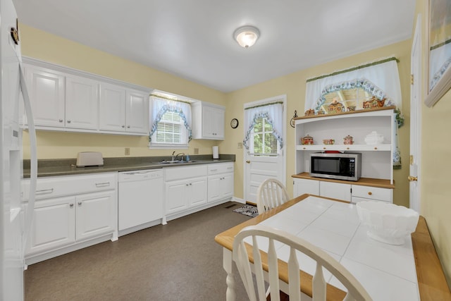 kitchen with tile counters, white appliances, white cabinetry, and sink