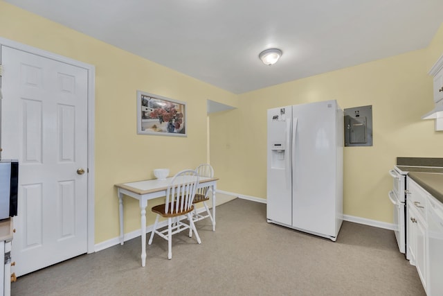 kitchen with light colored carpet, electric panel, white appliances, and white cabinetry