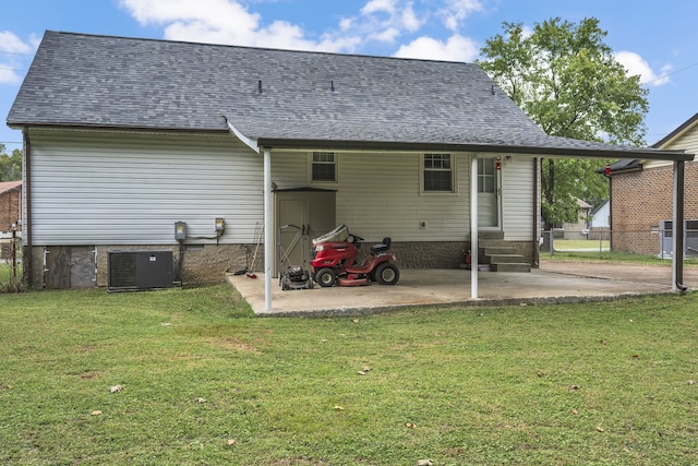 back of property featuring a lawn and central air condition unit