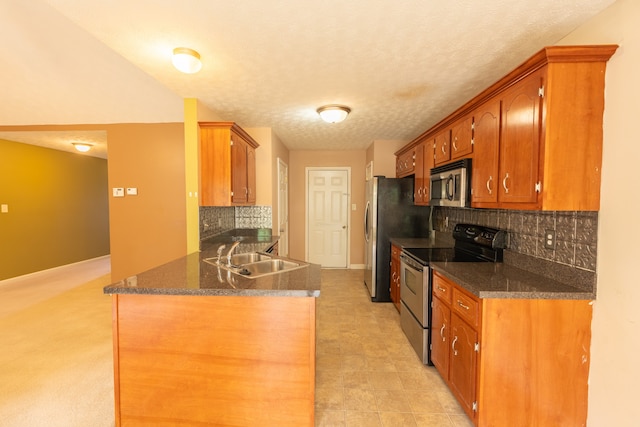 kitchen with sink, kitchen peninsula, tasteful backsplash, a textured ceiling, and appliances with stainless steel finishes