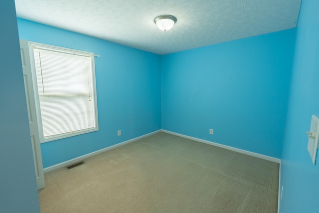 carpeted spare room with a textured ceiling