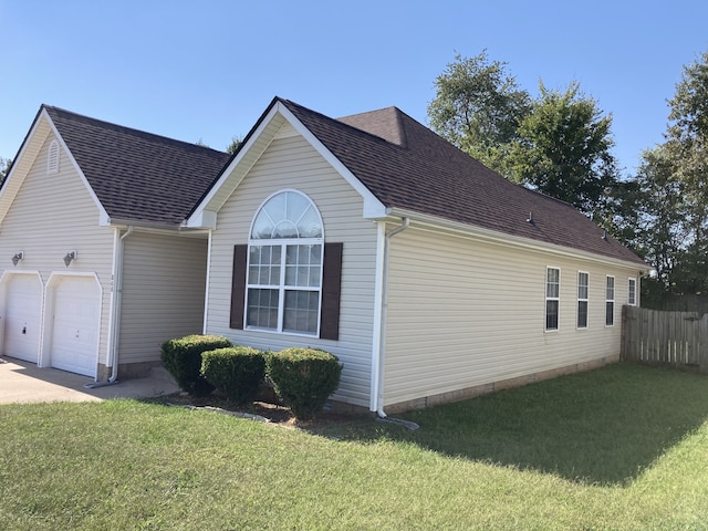 view of side of home with a lawn and a garage