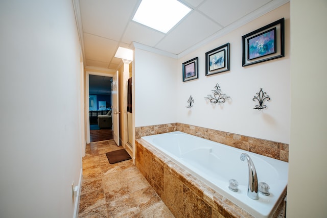 bathroom featuring ornamental molding and tiled tub