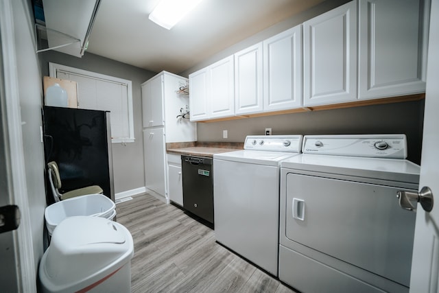 clothes washing area featuring cabinets, light wood-type flooring, and washing machine and clothes dryer