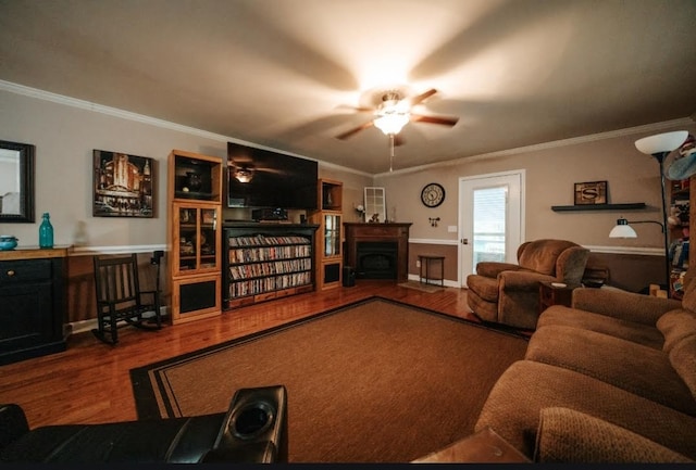 living room with ornamental molding, wood-type flooring, and ceiling fan