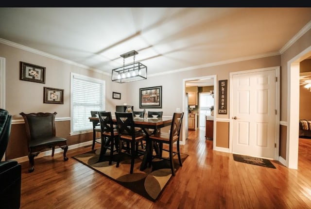 dining area with crown molding and hardwood / wood-style floors