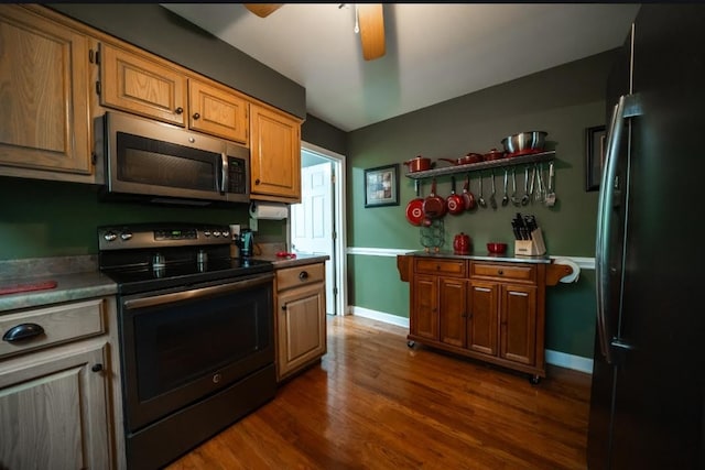 kitchen featuring stainless steel appliances, ceiling fan, and dark hardwood / wood-style floors