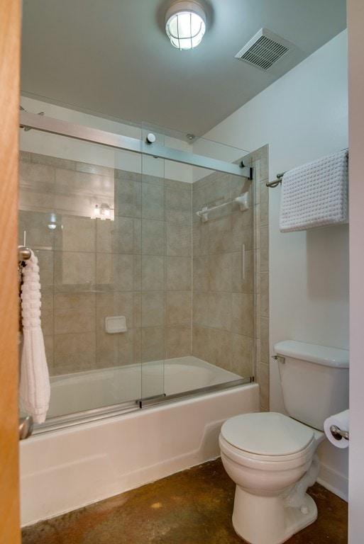 bathroom featuring combined bath / shower with glass door and toilet