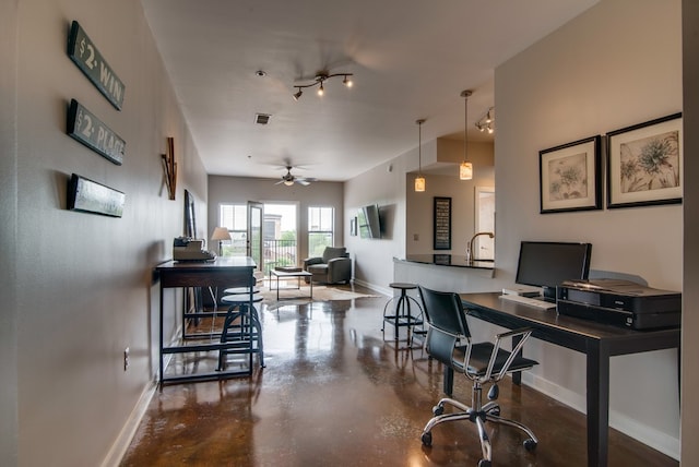 office space featuring ceiling fan and concrete floors