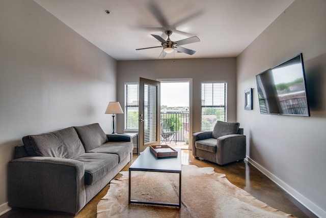 living room with concrete flooring, ceiling fan, and plenty of natural light