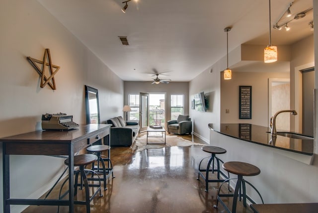 kitchen with ceiling fan, sink, concrete floors, decorative light fixtures, and rail lighting