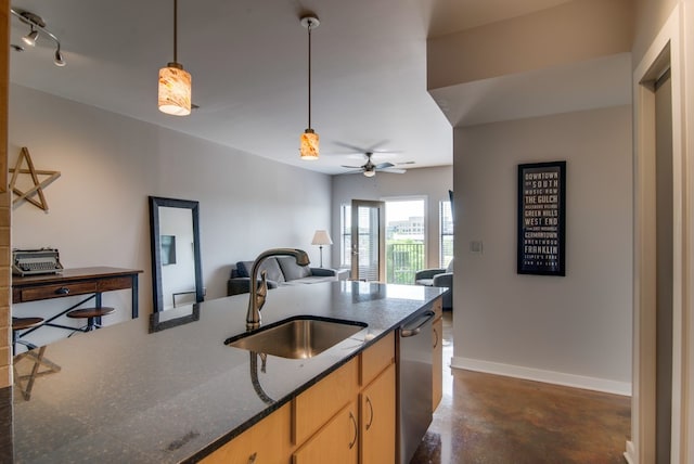 kitchen featuring dishwasher, sink, dark stone countertops, ceiling fan, and light brown cabinetry