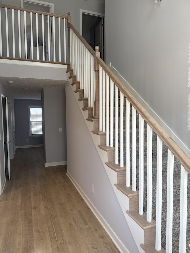 stairs with baseboards and wood finished floors