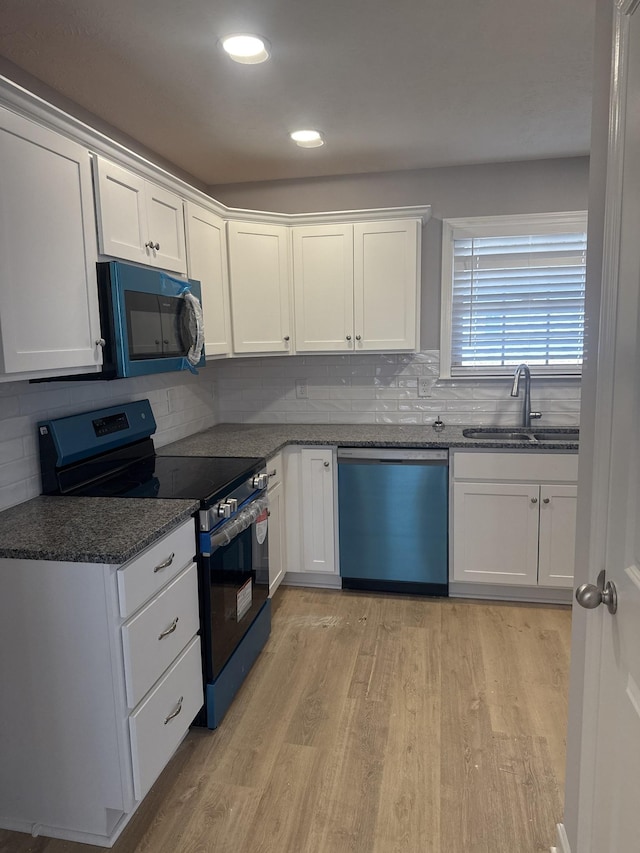 3261 Volta Rd, Christiana, TN 37037 - kitchen featuring dishwashing machine, black electric range oven, a sink, light wood finished floors, and backsplash