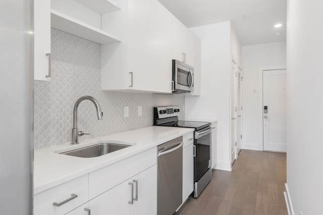 kitchen featuring white cabinets, appliances with stainless steel finishes, sink, and light hardwood / wood-style flooring