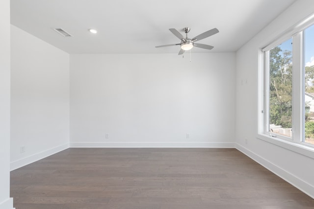 unfurnished room with dark wood-type flooring, ceiling fan, and a wealth of natural light