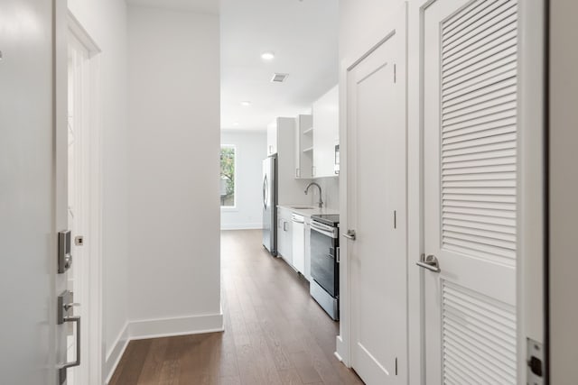 hallway with sink and dark wood-type flooring