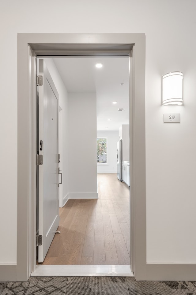 corridor with light hardwood / wood-style floors