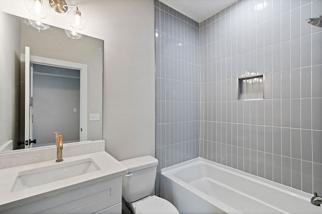 full bathroom featuring tiled shower / bath, vanity, and toilet