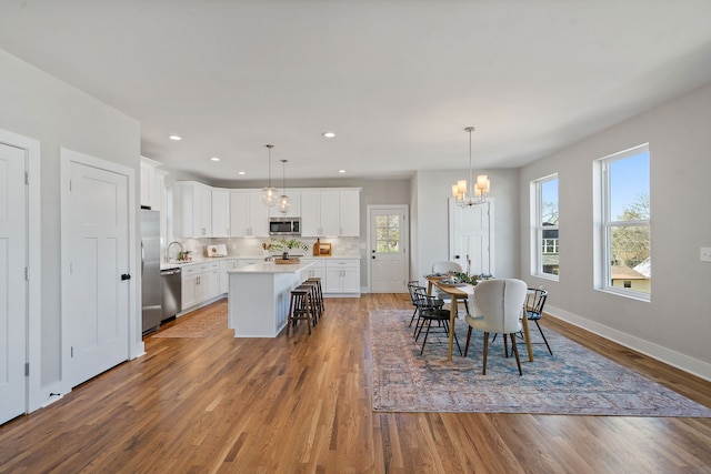 dining area featuring an inviting chandelier, sink, and hardwood / wood-style flooring