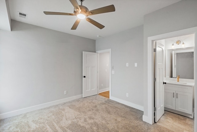 unfurnished bedroom featuring ceiling fan, light colored carpet, connected bathroom, and sink