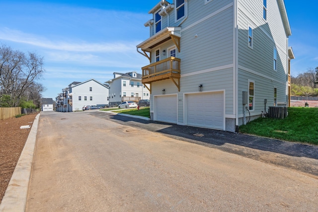 view of side of home featuring a balcony and a garage