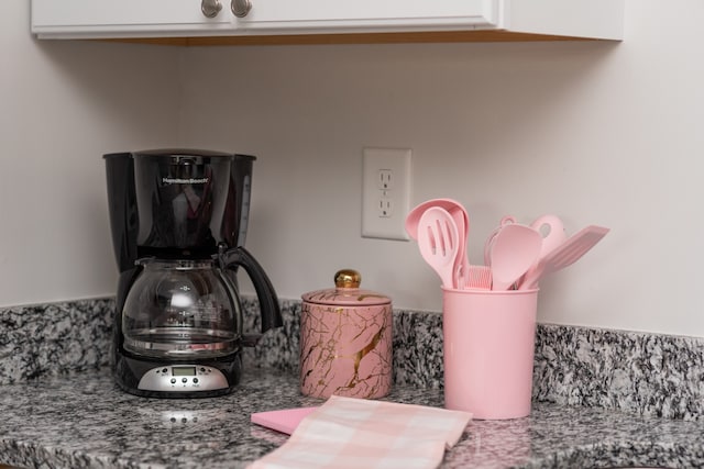 details featuring white cabinetry and stone countertops