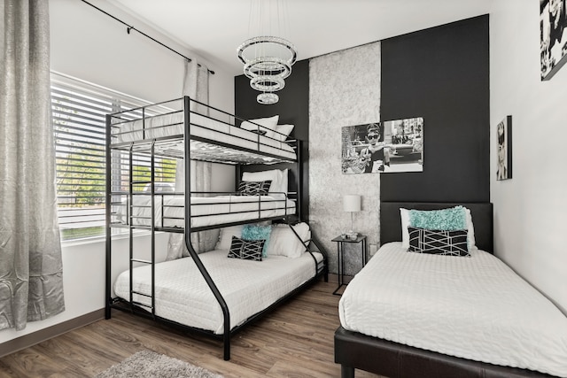 bedroom with an inviting chandelier and hardwood / wood-style flooring